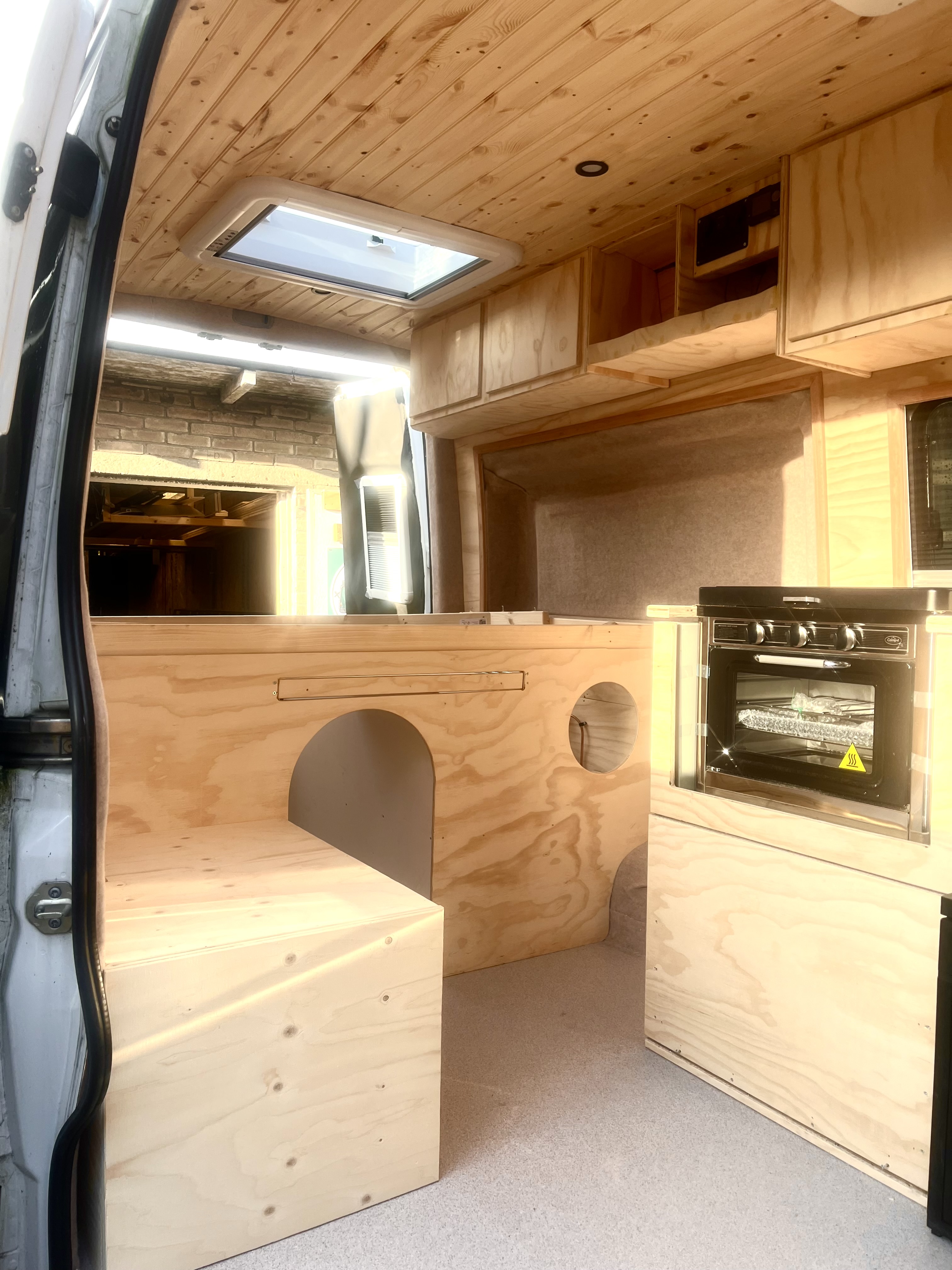 Interieur in opbouwfase: zithoek links, keuken met oven rechts en grenen plafond