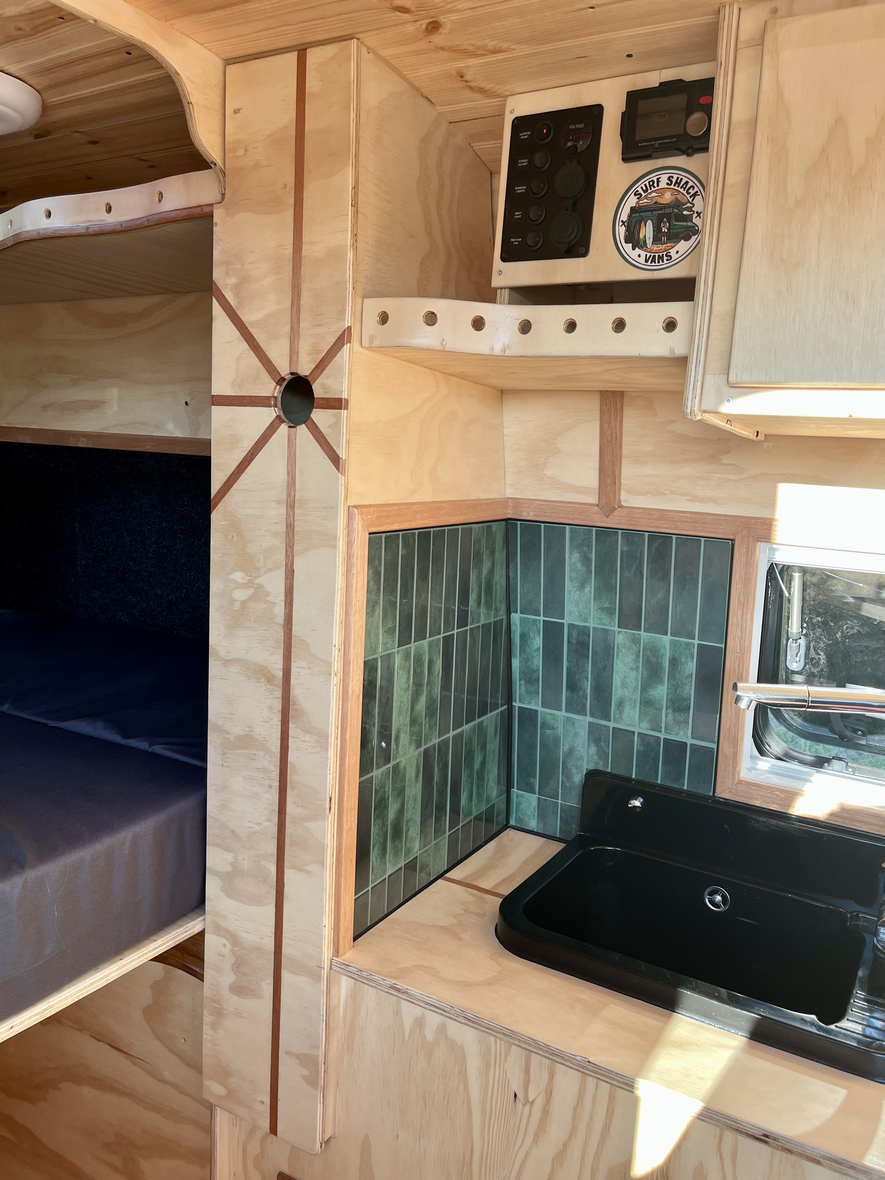 Keukenhoek met groene tegels, zwarte spoelbak en Surf Shack Vans bedieningspaneel