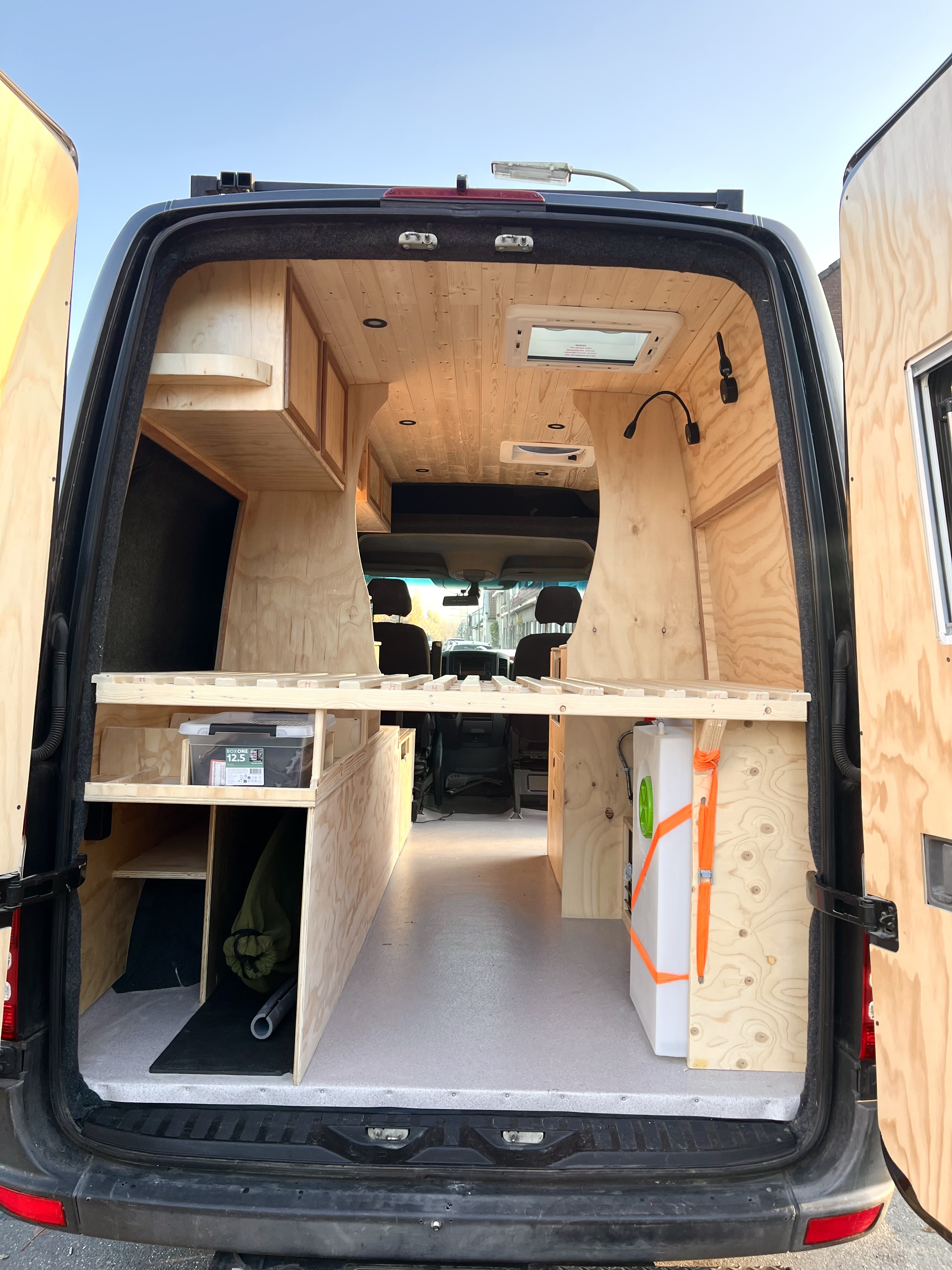 Aanzicht vanuit de achterdeuren: ruim interieur in opbouwfase met licht multiplex
