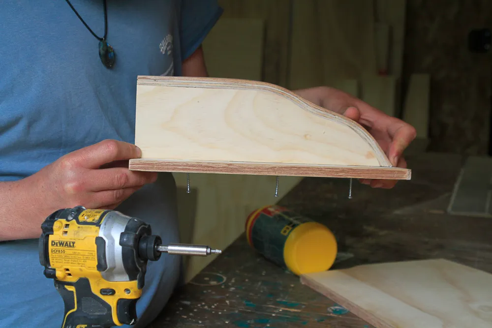Op maat gemaakt schap wordt gemonteerd in de werkplaats